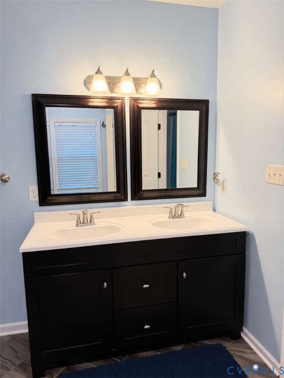 5424 Bellswood Drive, Mechanicsville, VA 23111 Double vanity featuring a dark-finish base cabinet, integrated dual-basin countertop, brushed-metal hardware, and dual framed wall mirrors with a three-light vanity fixture