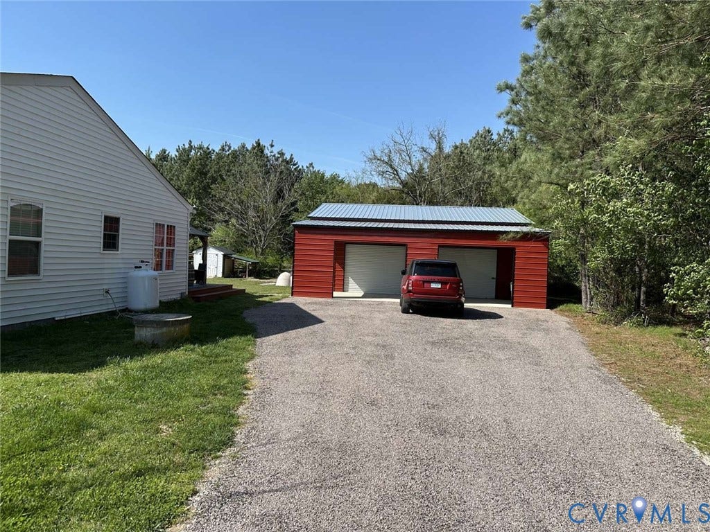5424 Bellswood Drive, Mechanicsville, VA 23111 Detached two-car garage with metal roofing, red horizontal siding, and gravel driveway