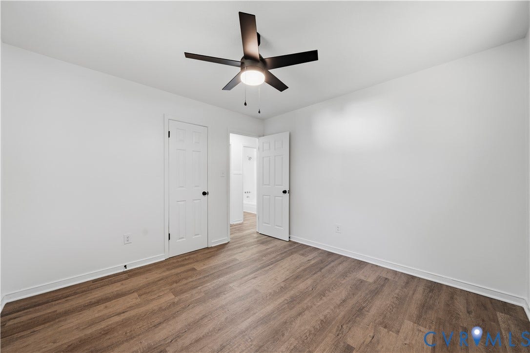 3622 New Bethel Road, Meherrin, VA 23954 Interior space featuring wood-finish flooring, a five-blade ceiling fan with integrated lighting, and two six-panel doors with matte black hardware