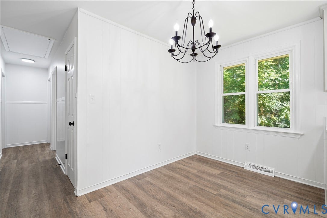 3622 New Bethel Road, Meherrin, VA 23954 Wood-finish flooring, white paneling, dual-pane window, and an intricate dark metal chandelier