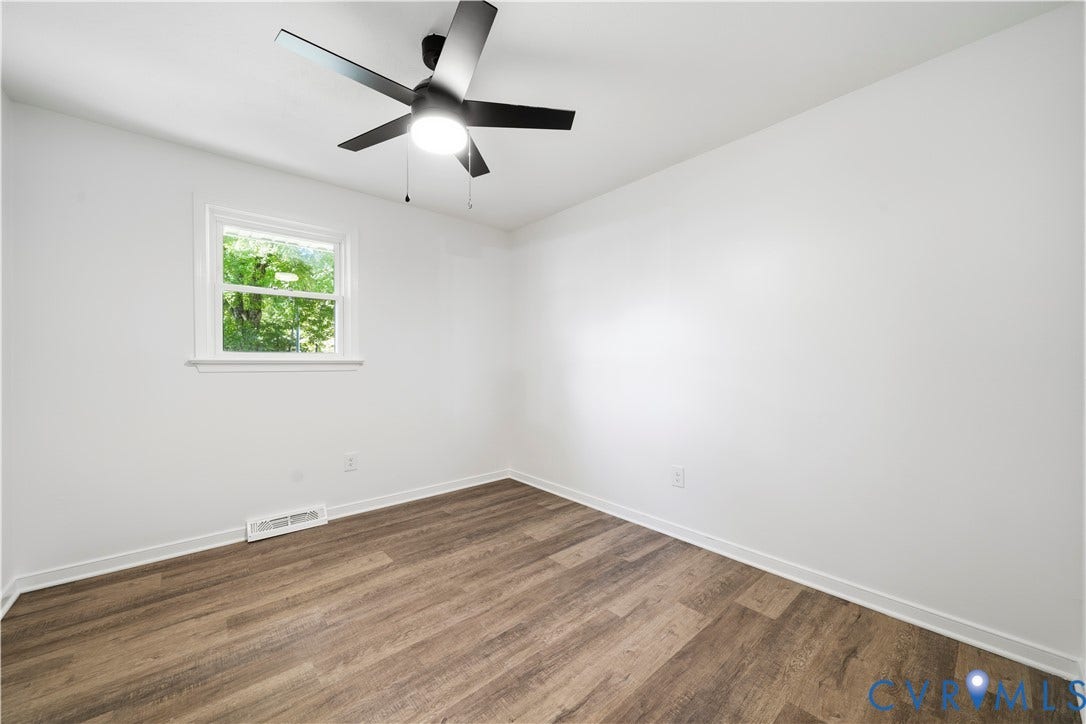 3622 New Bethel Road, Meherrin, VA 23954 Room featuring wood-finish flooring, a matte black multi-blade ceiling fan with integrated lighting, and a single-pane window