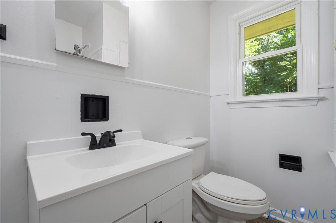 3622 New Bethel Road, Meherrin, VA 23954 White vanity with a solid surface countertop, integrated sink, matte black faucet, and matching black built-in wall fixtures