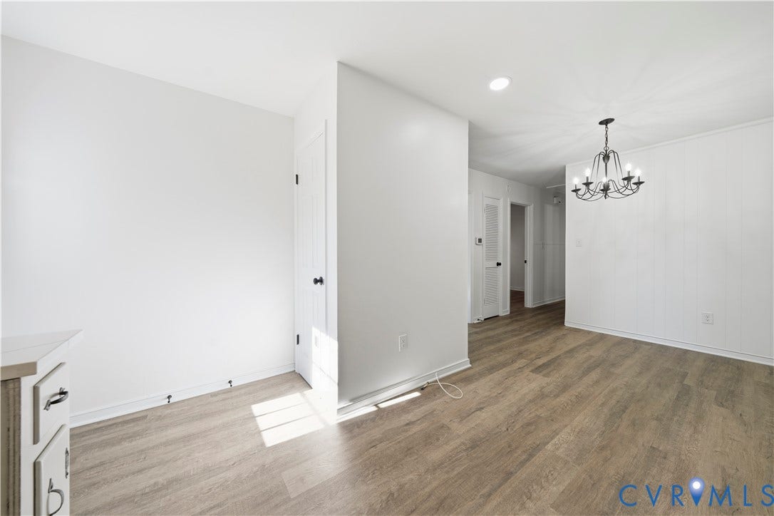 3622 New Bethel Road, Meherrin, VA 23954 Interior space featuring wood-finish flooring, white panel walls, and a multi-arm chandelier