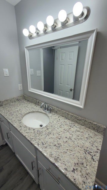510 Old Town Drive, Ellerslie, Colonial Heights, VA 23834 Vanity featuring stone-finish countertop, integrated undermount sink, white cabinetry with silver-tone hardware, framed mirror, and multi-bulb polished nickel light fixture