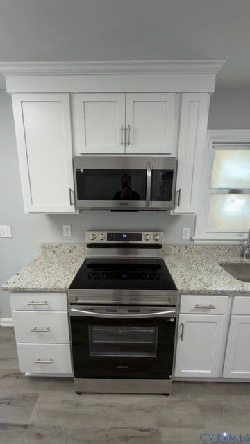 510 Old Town Drive, Ellerslie, Colonial Heights, VA 23834 Kitchen featuring white shaker-style cabinetry with crown molding, stone-patterned countertops, stainless steel electric range, built-in stainless steel microwave, and wood-finish flooring