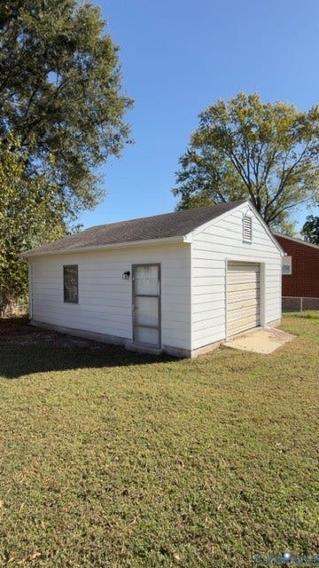 510 Old Town Drive, Ellerslie, Colonial Heights, VA 23834 Detached garage featuring white horizontal siding, a pitched asphalt shingle roof, a roll-up garage door, and a side-entry door