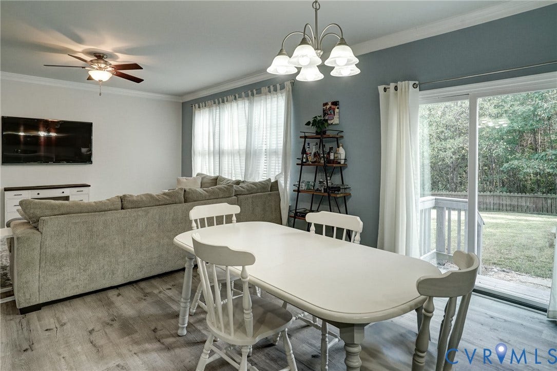 8909 Hollycroft Court, Mechanicsville, VA 23116 Living area featuring wood-finish flooring, crown molding, a ceiling fan, a five-light chandelier, and a sliding glass door