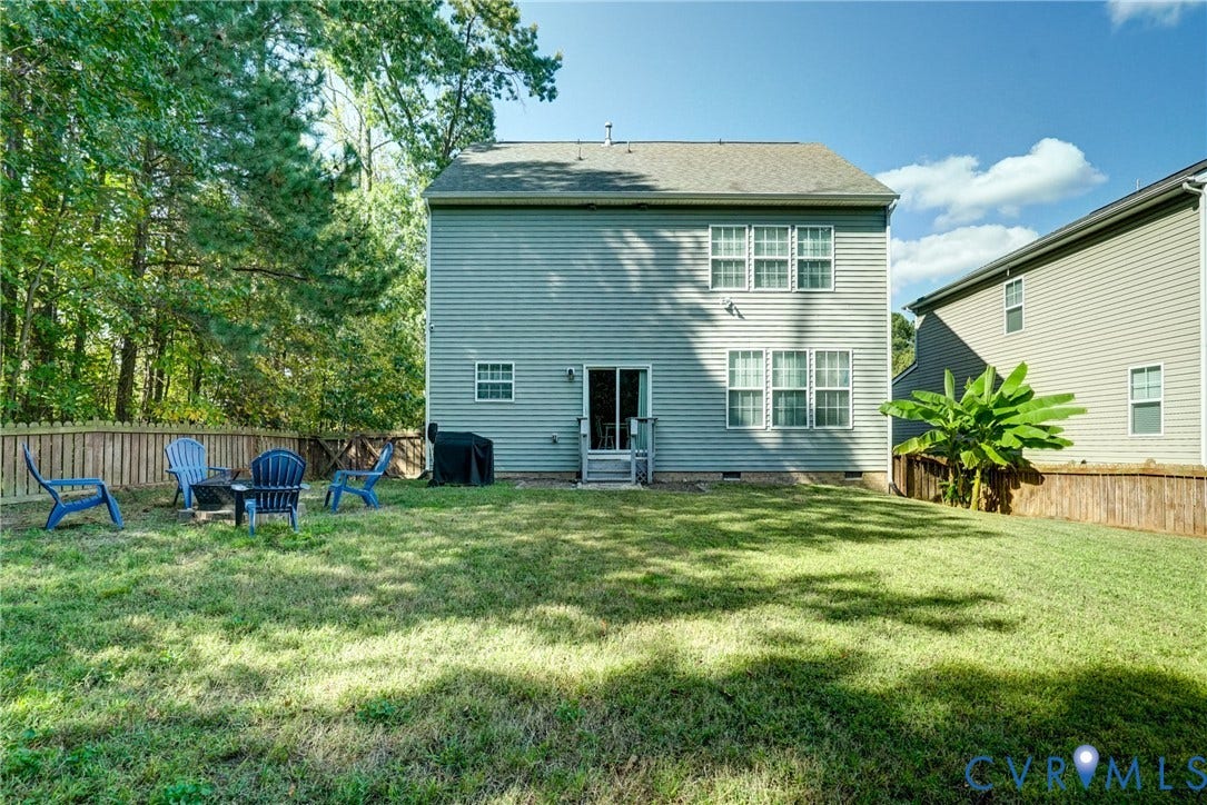 8909 Hollycroft Court, Mechanicsville, VA 23116 Two-story residence featuring light-toned horizontal siding, a rear sliding glass door, a fenced backyard, and mature surrounding trees