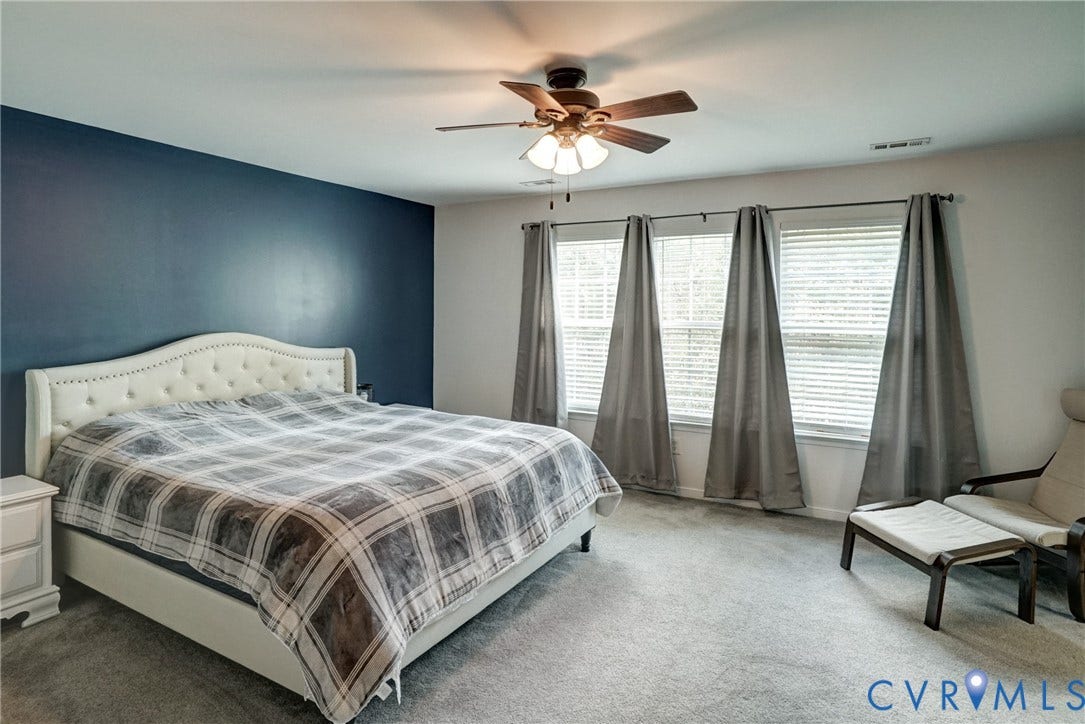 8909 Hollycroft Court, Mechanicsville, VA 23116 Room featuring a deep blue accent wall, neutral carpeting, and a multi-light ceiling fan