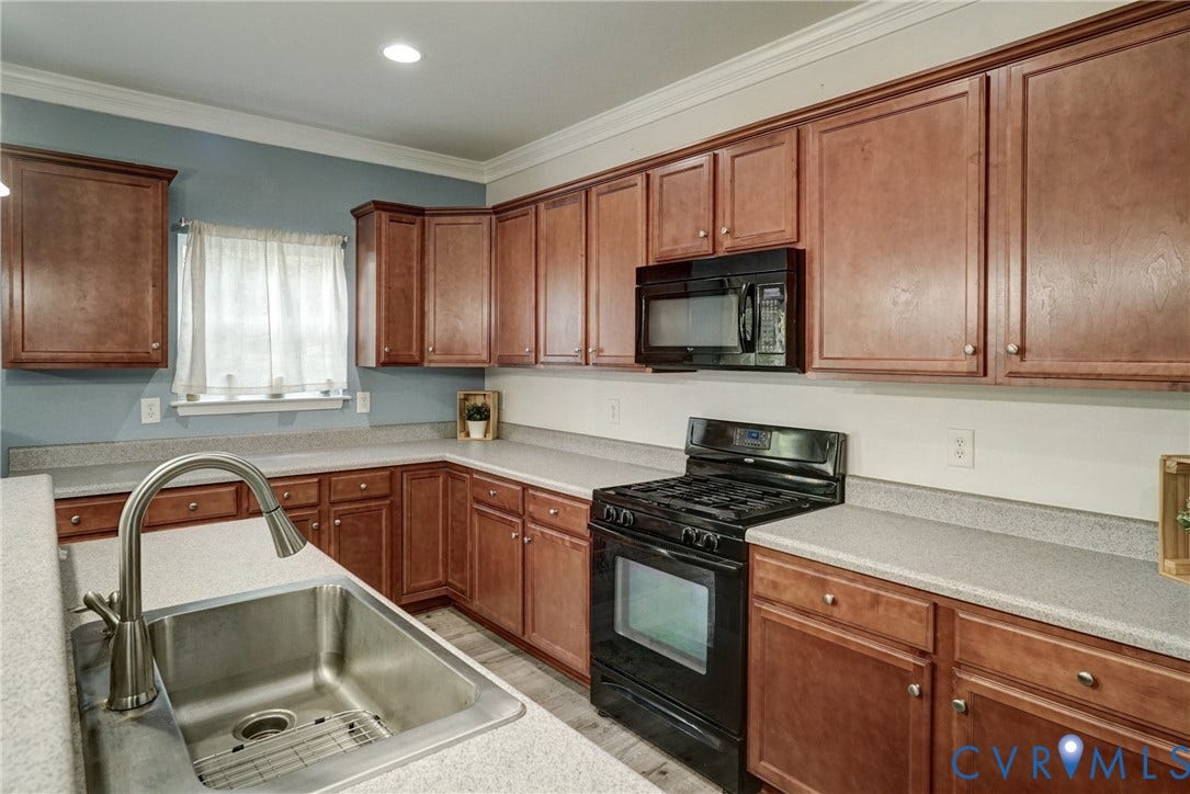 8909 Hollycroft Court, Mechanicsville, VA 23116 Kitchen featuring stained wood cabinetry, stone-finish countertops, stainless steel undermount sink with a high-arch pull-down faucet, and a black built-in microwave and range
