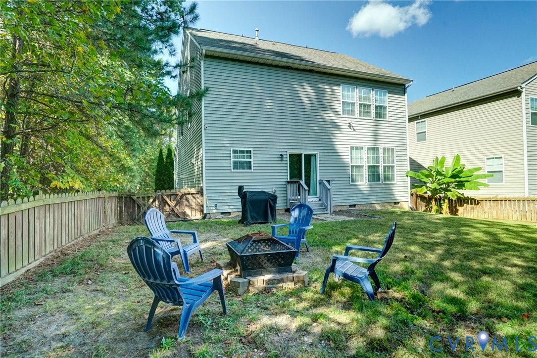 8909 Hollycroft Court, Mechanicsville, VA 23116 Rear exterior featuring light-toned horizontal siding, a fenced backyard, and mature trees