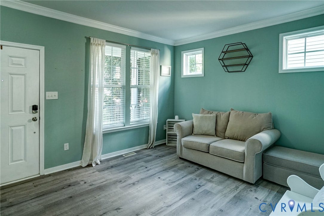 8909 Hollycroft Court, Mechanicsville, VA 23116 Interior space featuring wood-finish flooring, crown molding, double-hung windows with integrated shutters, and a six-panel exterior entry door