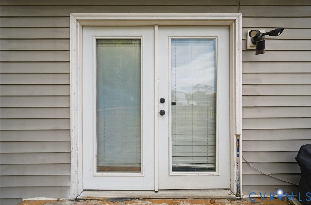 1101 Arch Hill Drive, Chesterfield, VA 23236 Double glass-panel doors featuring integrated blinds, horizontal lap siding, and exterior security lighting