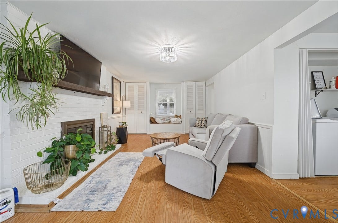 1101 Arch Hill Drive, Chesterfield, VA 23236 Painted brick fireplace with a wood mantel, wood-finish flooring, built-in window seat, ceiling-mounted light fixture, and louvered closet doors