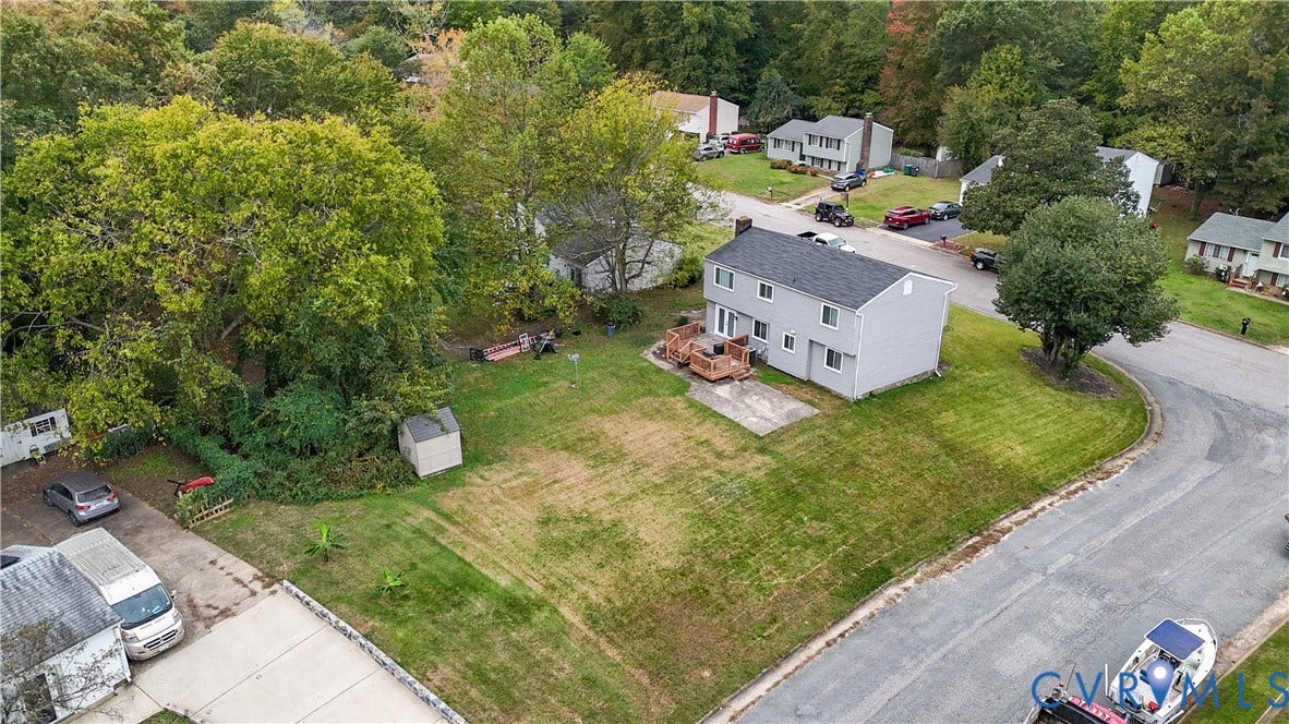 1101 Arch Hill Drive, Chesterfield, VA 23236 Two-story residence featuring light-toned siding, a rear wood deck, a concrete patio, a dedicated storage shed, and a spacious lawn area