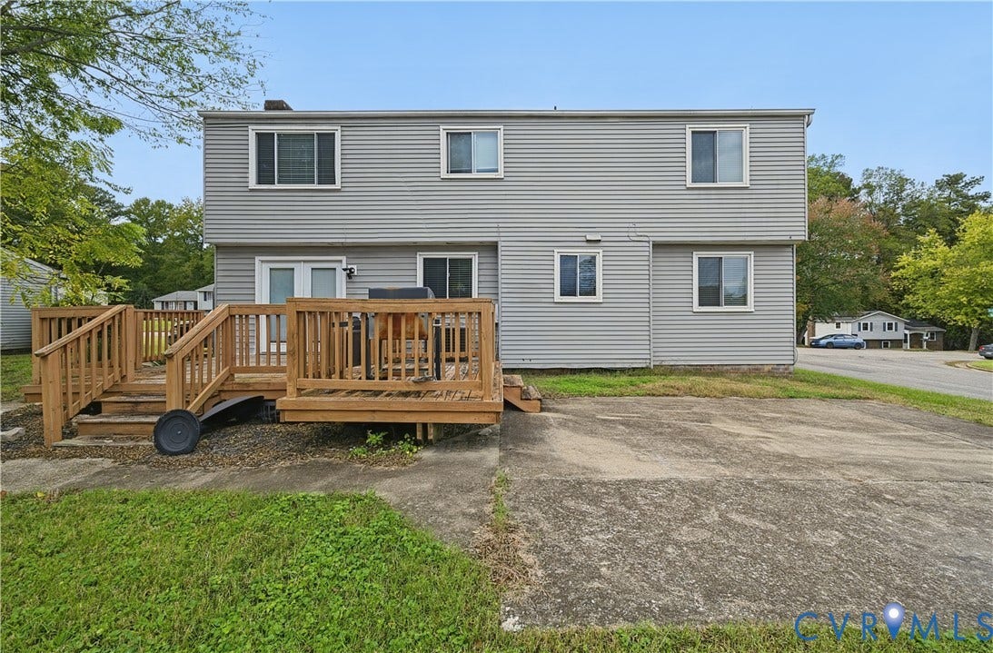 1101 Arch Hill Drive, Chesterfield, VA 23236 Two-story residence featuring light gray horizontal siding, an elevated wood deck, and a concrete patio
