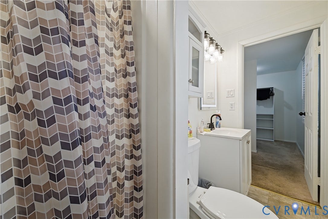 1101 Arch Hill Drive, Chesterfield, VA 23236 White vanity with integrated sink, oil-rubbed bronze finish faucet, multi-bulb vanity light fixture, and wall-mounted storage cabinetry