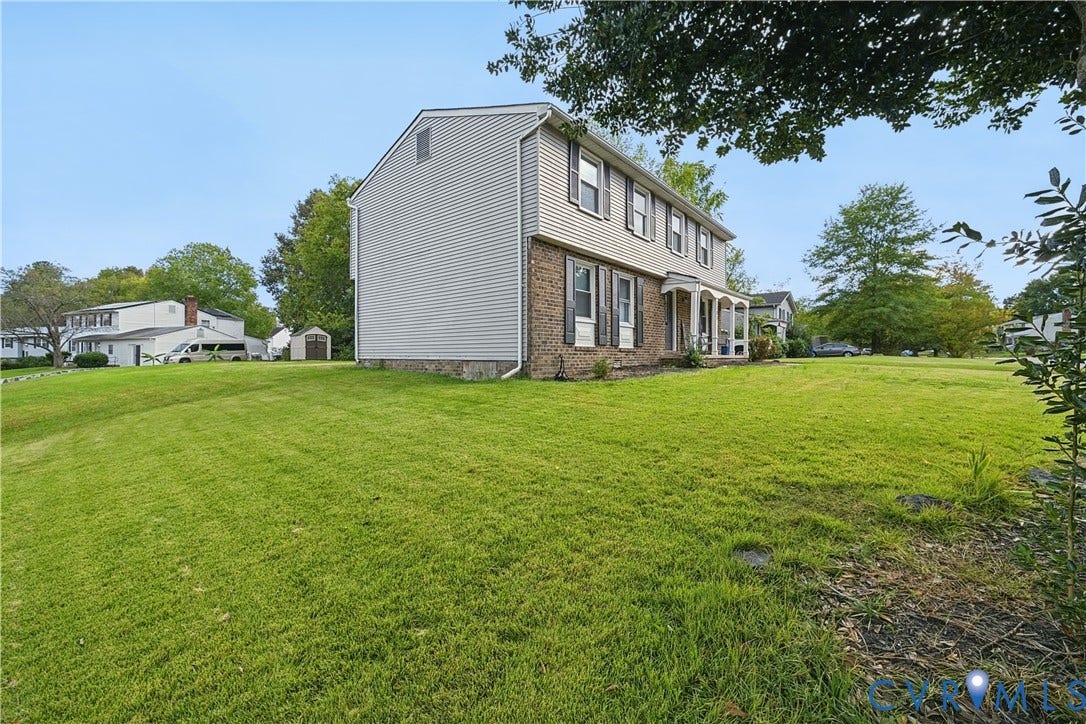 1101 Arch Hill Drive, Chesterfield, VA 23236 Two-story exterior featuring light-toned horizontal siding, a partial brick facade, shuttered windows, and an expansive lawn