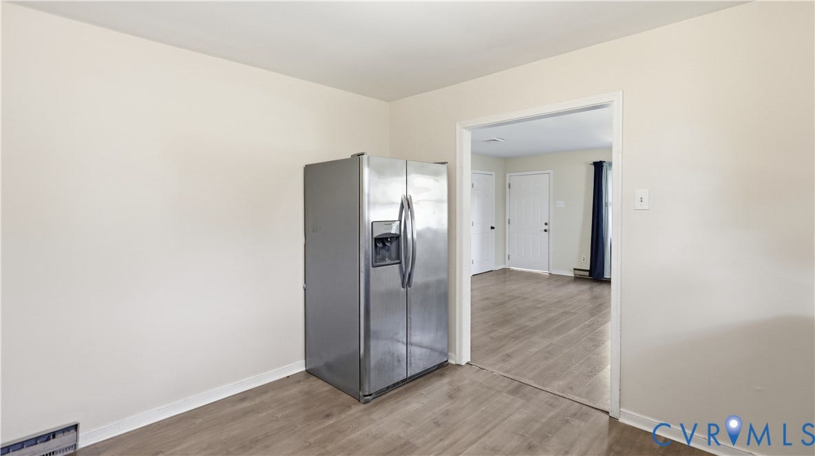 Stainless steel side-by-side refrigerator and wood-finish flooring
