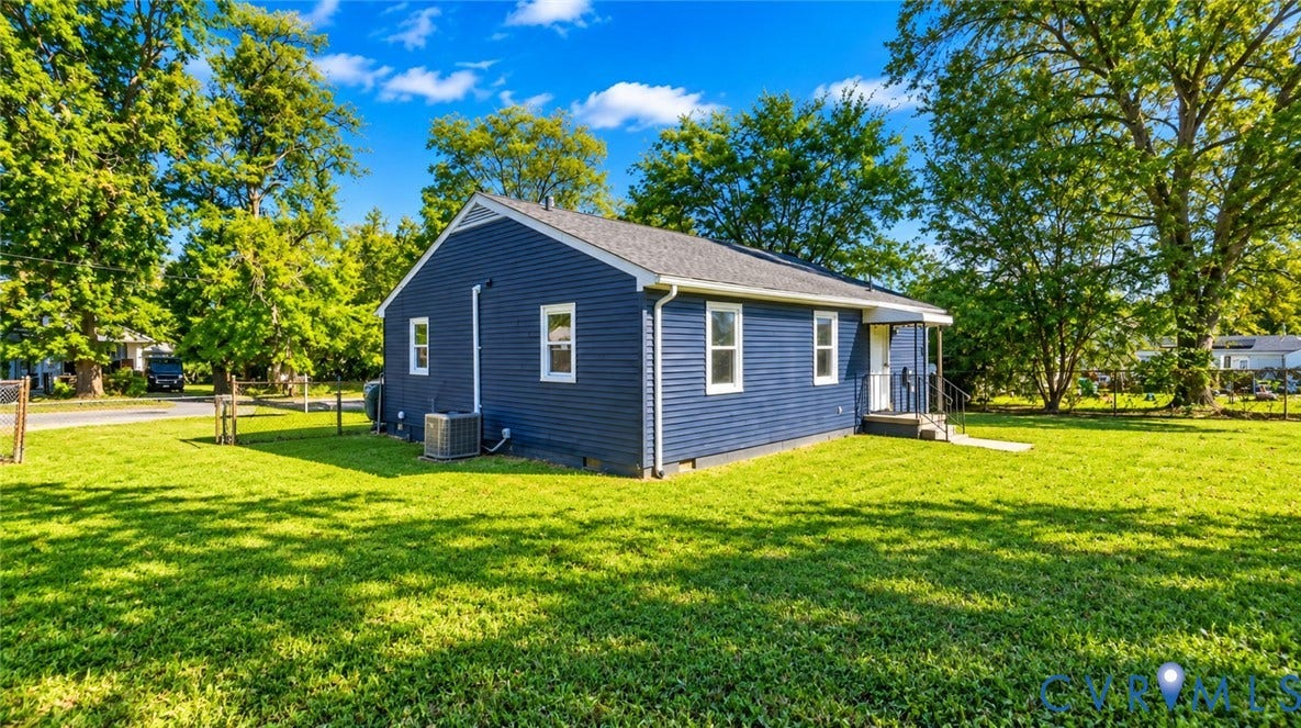 Blue horizontal siding exterior with a gable roof, white trim, and a fenced yard