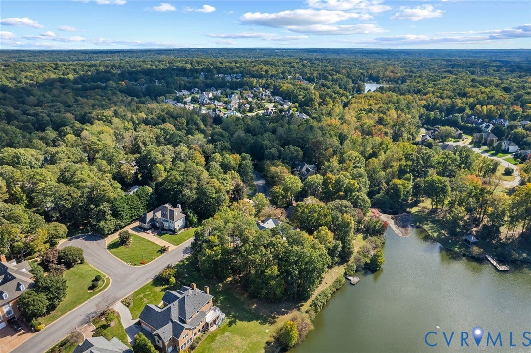 11433 Barrington Bridge Court, Henrico, VA 23233 Aerial perspective featuring waterfront property, expansive wooded acreage, paved street infrastructure, and multiple detached residential structures