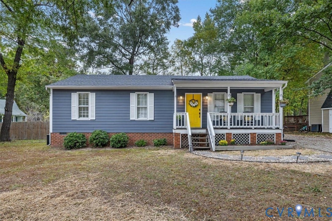 11518 Frederick Farms Circle, Midlothian, VA 23112 Exterior featuring blue horizontal siding, a red brick foundation, a covered front porch with white railing, and a vibrant yellow entry door