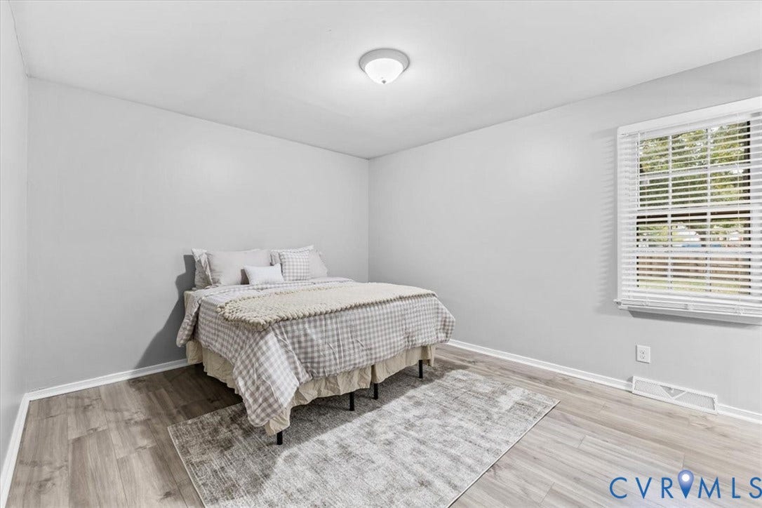 11518 Frederick Farms Circle, Midlothian, VA 23112 Neutral-toned walls, wood-finish flooring, and a single-pane window with white horizontal blinds