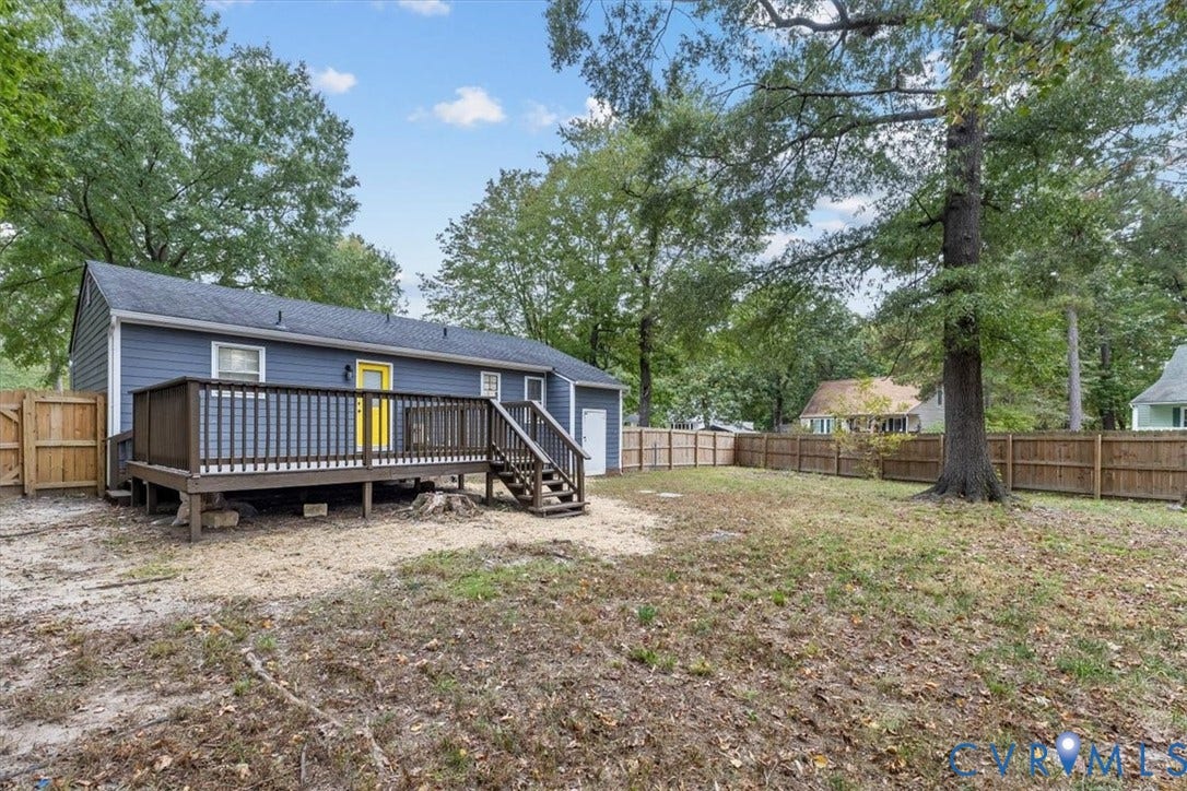 11518 Frederick Farms Circle, Midlothian, VA 23112 Rear exterior featuring a raised wood deck with stair access, horizontal lap siding, and a fully fenced perimeter with wood privacy fencing