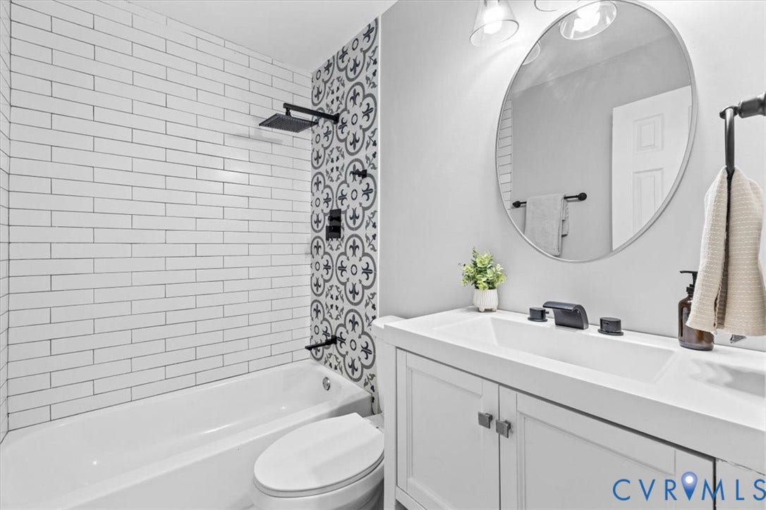 11518 Frederick Farms Circle, Midlothian, VA 23112 Bathroom featuring white subway tile, decorative patterned accent tile, matte black shower fixtures, vanity with an integrated sink, and an oval wall-mounted mirror