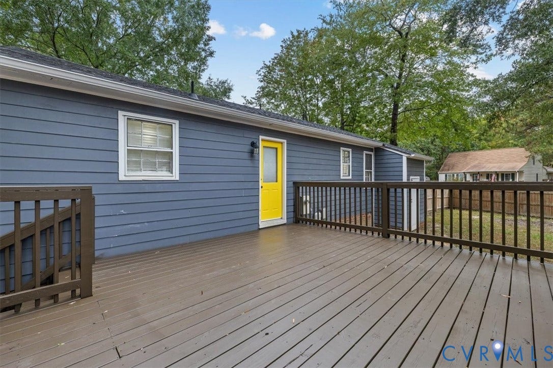 11518 Frederick Farms Circle, Midlothian, VA 23112 Spacious elevated wood-finish deck with railings, blue horizontal siding, and an exterior door
