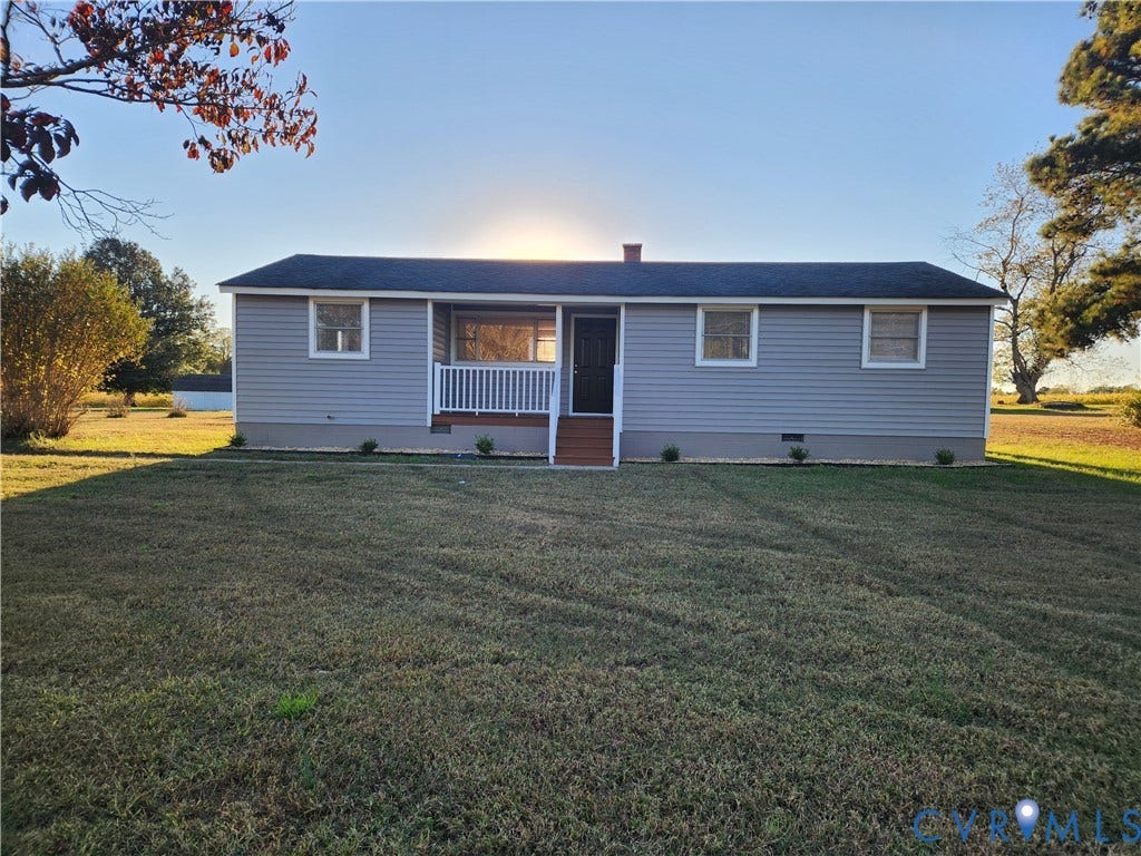 1209 Newtown Road, King & Queen, VA 23148 Single-story residence featuring grey vinyl siding, a gabled roof, an elevated front porch with a white railing, and a sprawling lawn