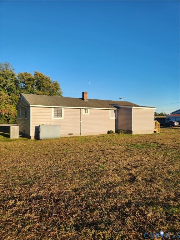 1209 Newtown Road, King & Queen, VA 23148 Exterior featuring horizontal siding, a central chimney, asphalt shingle roofing, and an expansive open lot