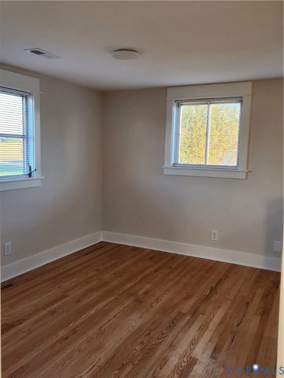 1209 Newtown Road, King & Queen, VA 23148 Room featuring natural wood-finish flooring, neutral wall paint, and dual windows with wide-profile white trim