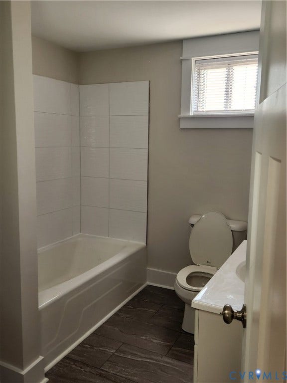 1209 Newtown Road, King & Queen, VA 23148 Bathroom featuring wood-finish tile flooring, a white porcelain tub with integrated tile surround, a crisp white vanity, and a window with white trim