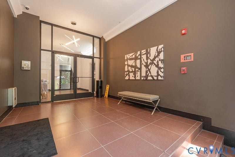 6 N 6th Street, #U3C, Downtown, Richmond, VA 23219 Building lobby featuring tile flooring, a glass-paned double entry door, geometric overhead lighting, and crown molding