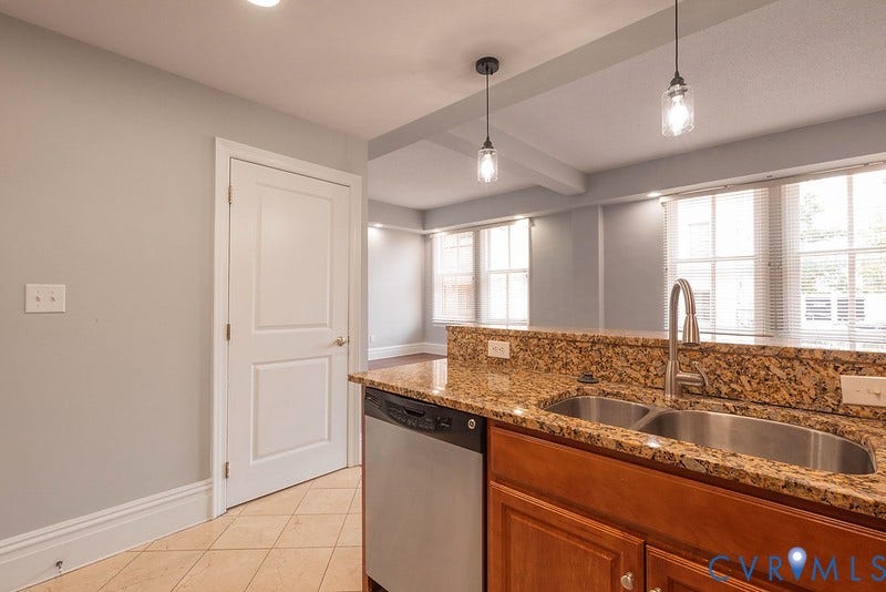 6 N 6th Street, #U3C, Downtown, Richmond, VA 23219 Kitchen featuring natural stone countertops, stainless steel undermount double-basin sink, high-arc faucet, wood cabinetry, and pendant lighting