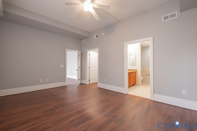 6 N 6th Street, #U3C, Downtown, Richmond, VA 23219 Interior room featuring tray ceilings, a ceiling fan, wood-finish flooring, and multi-panel interior doors