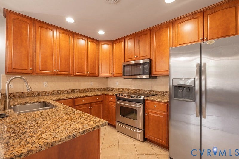 6 N 6th Street, #U3C, Downtown, Richmond, VA 23219 Kitchen featuring wood cabinetry, stone countertops, stainless steel appliances, a built-in microwave, and tile flooring