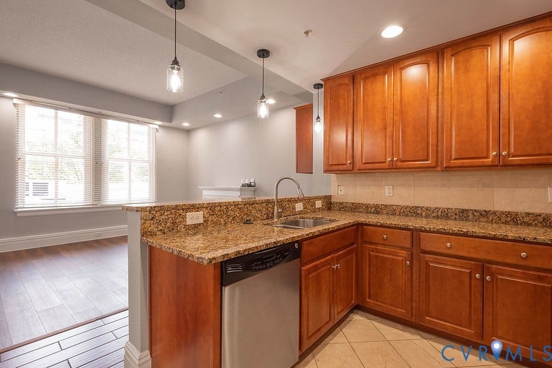 6 N 6th Street, #U3C, Downtown, Richmond, VA 23219 Kitchen featuring wood cabinetry, stone-surface countertops, tile backsplash, stainless steel dishwasher, and pendant lighting