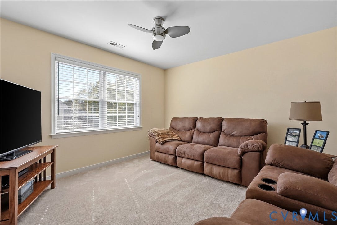 4914 Terrace Arbor Circle, Midlothian, VA 23112 Neutral-toned room featuring wall-to-wall carpeting, a large double-hung window, and a brushed nickel ceiling fan with integrated light