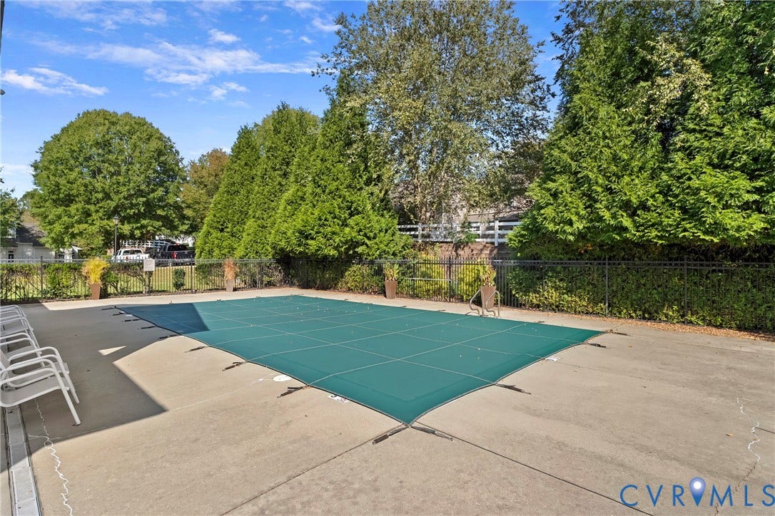 4914 Terrace Arbor Circle, Midlothian, VA 23112 Community In-ground pool, concrete pool deck, and perimeter black metal fencing surrounded by mature evergreen trees