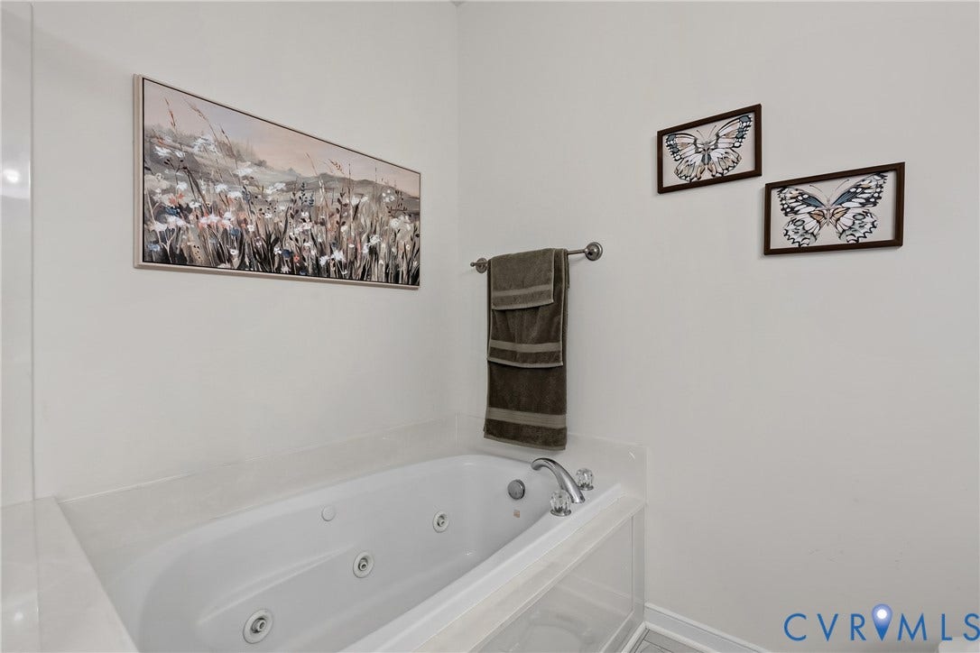 4914 Terrace Arbor Circle, Midlothian, VA 23112 Jetted soaking tub featuring a deck-mounted chrome faucet, surrounding paneling, and an integrated towel bar