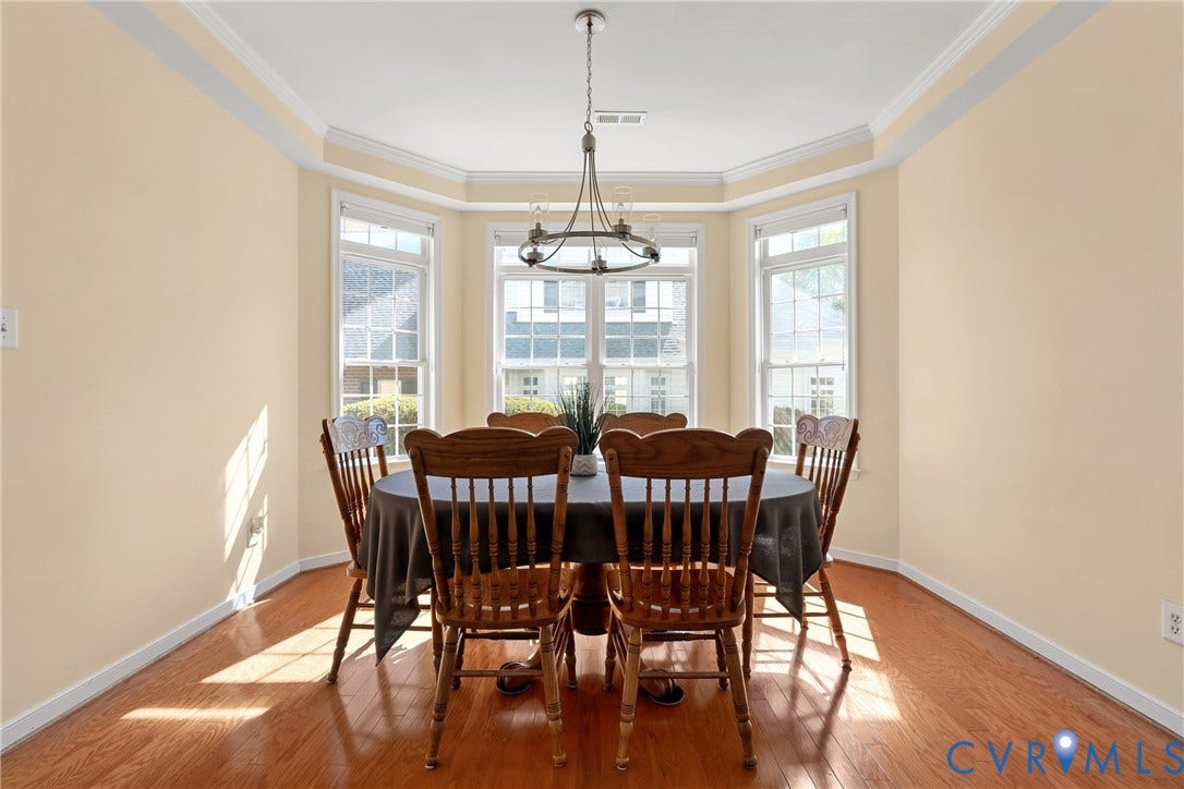 4914 Terrace Arbor Circle, Midlothian, VA 23112 Dining space featuring bay windows, wood-finish flooring, tray ceiling, crown molding, and a tiered metal chandelier