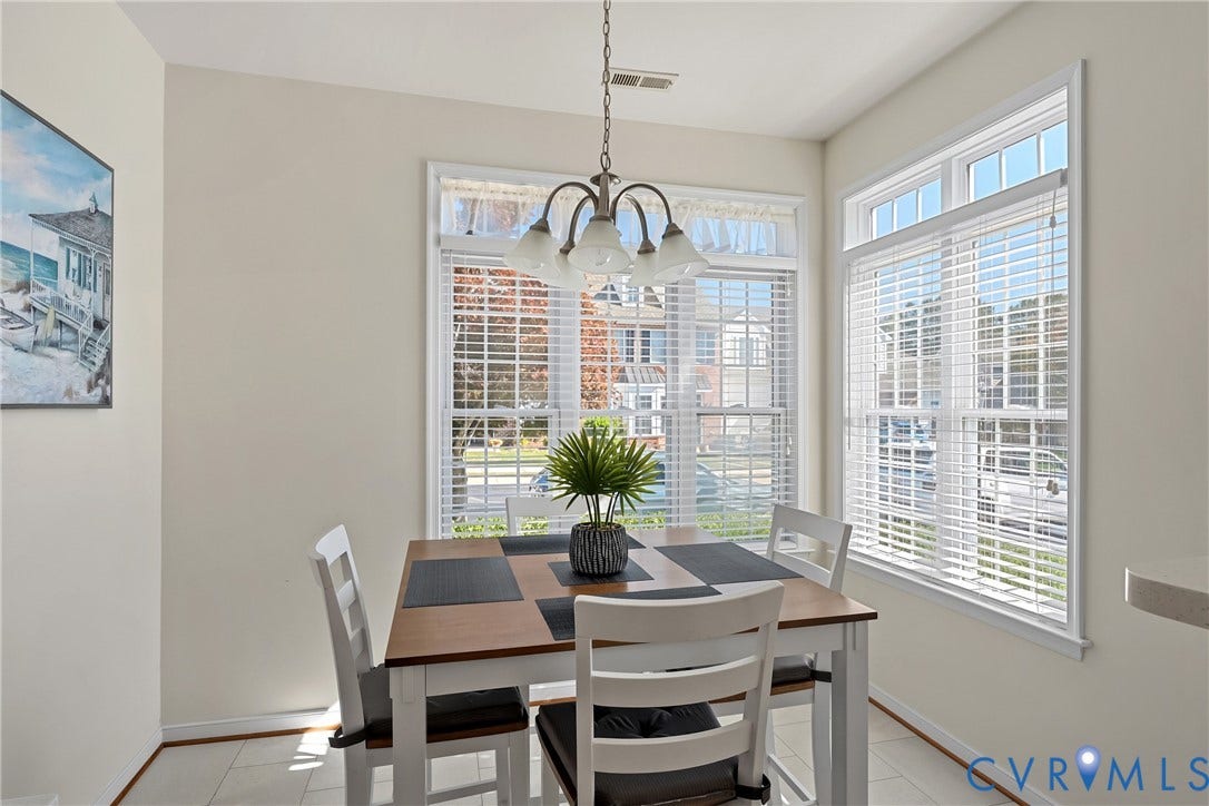 4914 Terrace Arbor Circle, Midlothian, VA 23112 Sun-drenched dining area featuring large windows with integrated blinds, LVT flooring, and a multi-arm pendant light fixture