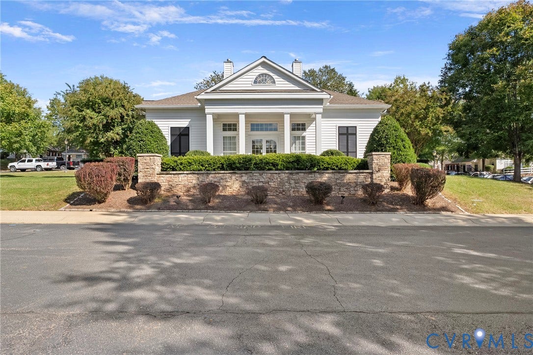 4914 Terrace Arbor Circle, Midlothian, VA 23112 Clubhouse with classical exterior featuring a gabled roofline, prominent white columns, horizontal siding, masonry retaining wall, and arched transom window details