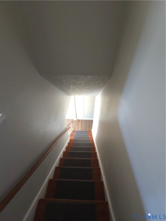 413 Adamson Street, Henrico, VA 23075 Staircase featuring wood-finish treads, central carpeted runners, and a wall-mounted wooden handrail