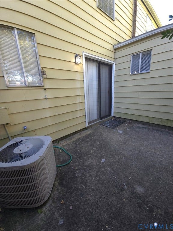 413 Adamson Street, Henrico, VA 23075 Exterior siding, sliding glass door with integrated screen, concrete patio, and wall-mounted exterior lighting