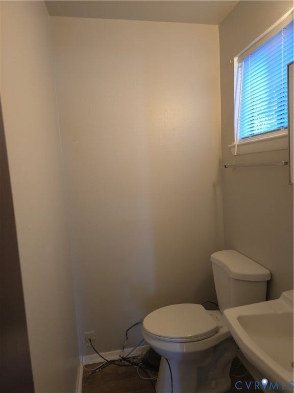413 Adamson Street, Henrico, VA 23075 Neutral-toned walls, pedestal sink, white porcelain toilet, and horizontal window blinds