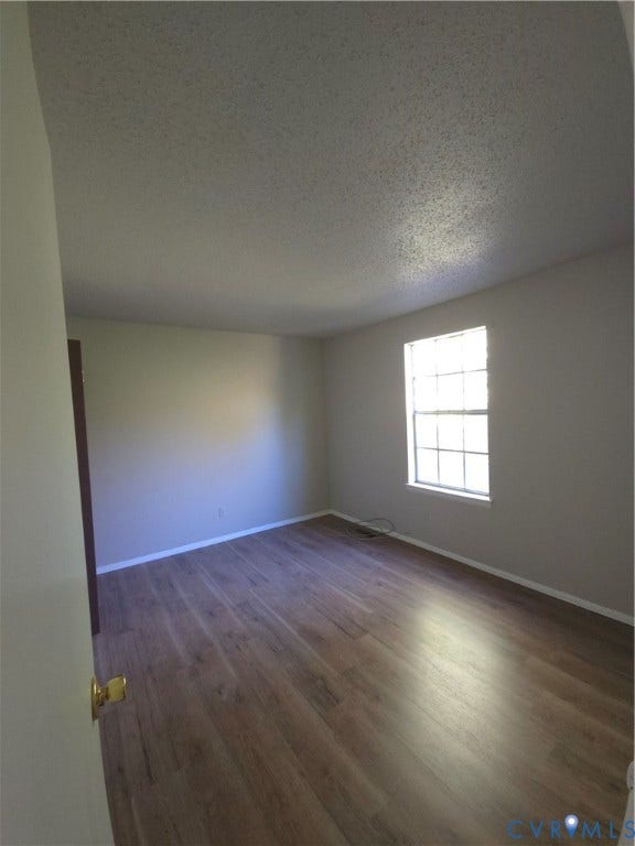413 Adamson Street, Henrico, VA 23075 Interior space featuring neutral wall paint, wood-finish flooring, and a single-hung window with a grid pattern