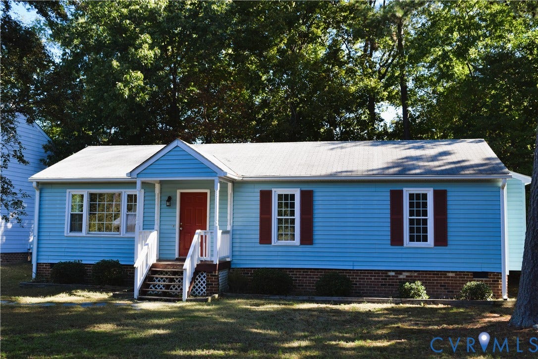 8905 Hawkbill Road, Chesterfield, VA 23237 Single-story residence featuring horizontal siding, brick masonry foundation, covered front porch with white railing, and decorative window shutters